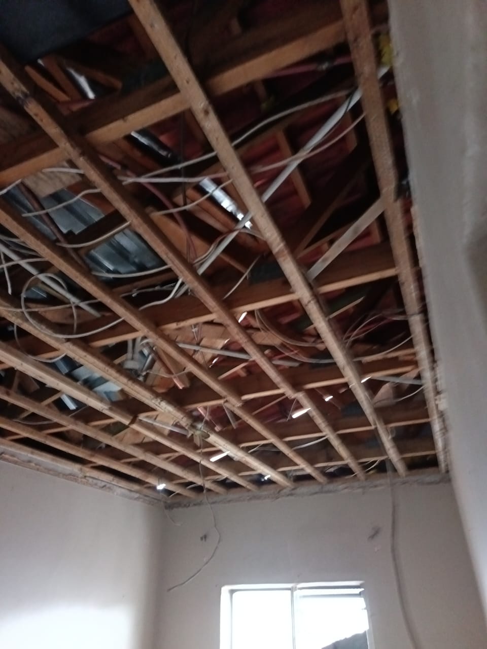 Structural ceiling repair revealing wooden brandering